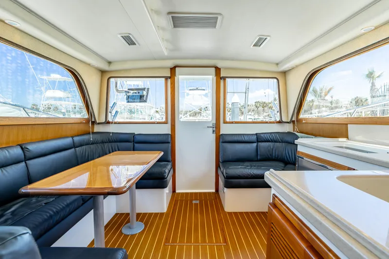 Slide: The Image of Interior of 2002 Cabo 35 Flybridge yacht with sleek seating and wooden flooring. - 17