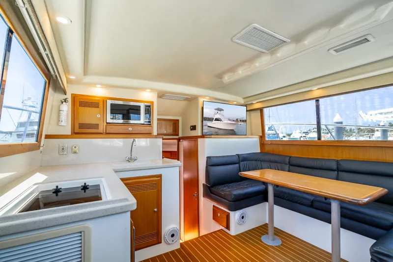 Slide: The Image of Interior of 2002 Cabo 35 Flybridge yacht with kitchenette and seating area. - 18