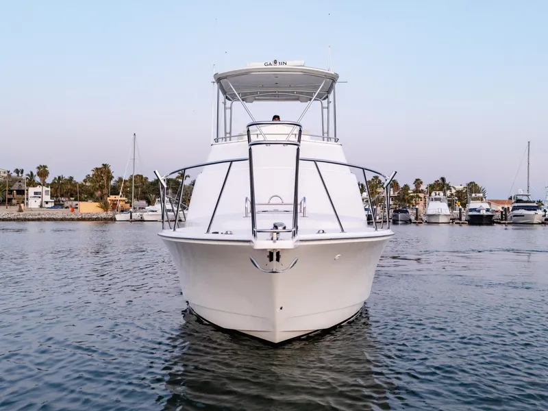 Slide: The Image of 2002 Cabo 35 Flybridge yacht on calm water, marina background. - 2