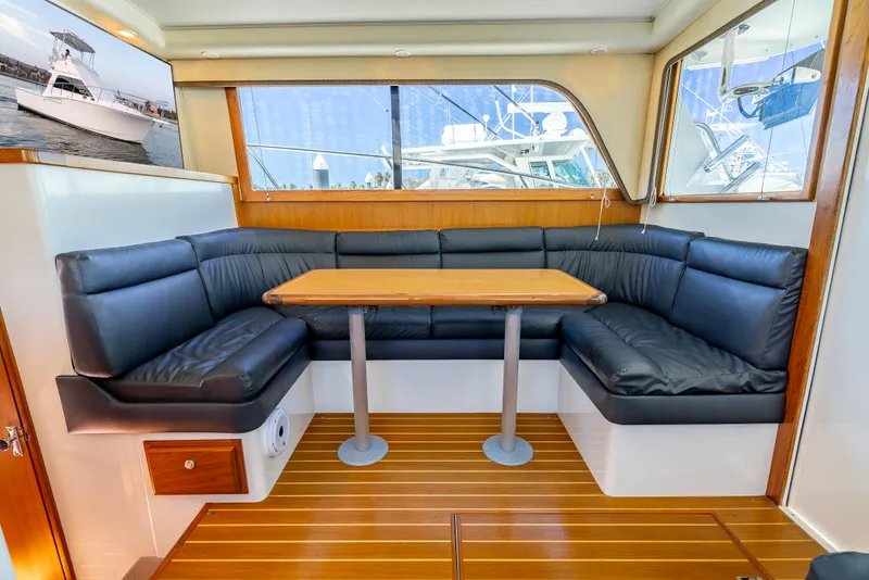 Slide: The Image of Interior of 2002 Cabo 35 Flybridge with leather seating and wooden table. - 20
