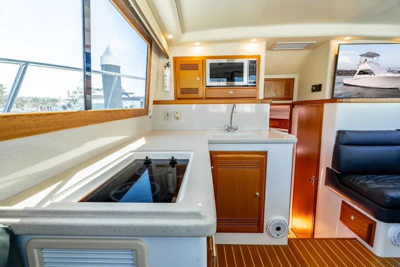 Slide: The Image of Interior of 2002 Cabo 35 Flybridge yacht with kitchenette and seating area. - 21
