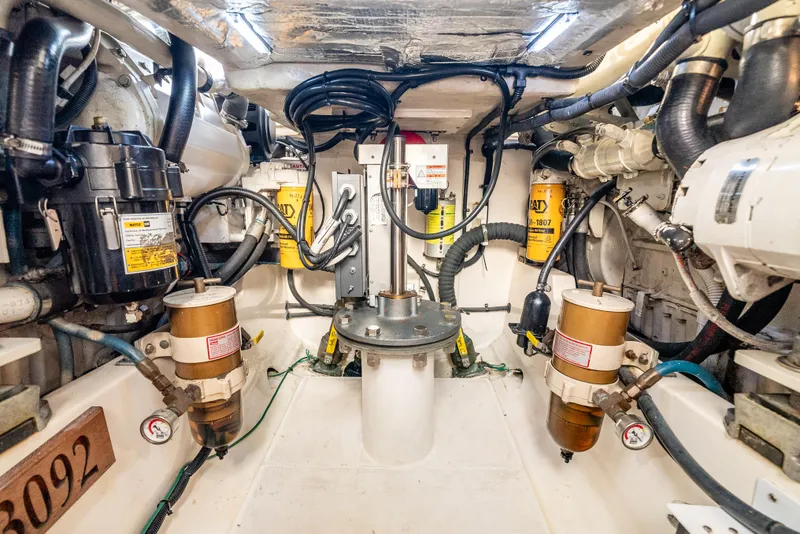 Slide: The Image of Engine room of 2002 Cabo 35 Flybridge with filters, hoses, and mechanical components. - 32