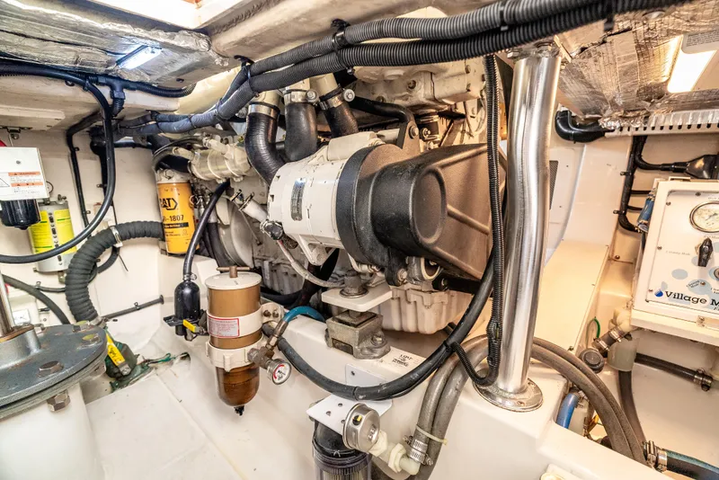 Slide: The Image of Engine room of 2002 Cabo 35 Flybridge boat, showcasing mechanical components and wiring. - 34