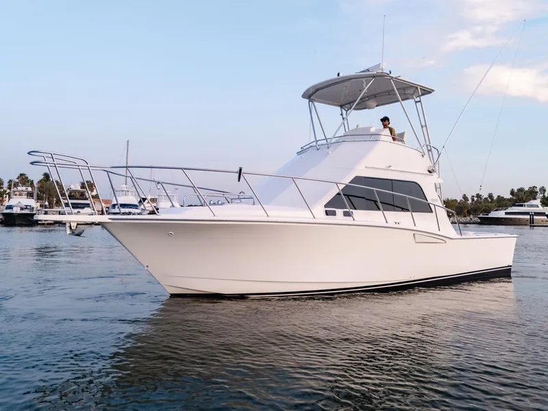 Slide: The Image of 2002 Cabo 35 Flybridge yacht cruising in a serene marina setting. - 4