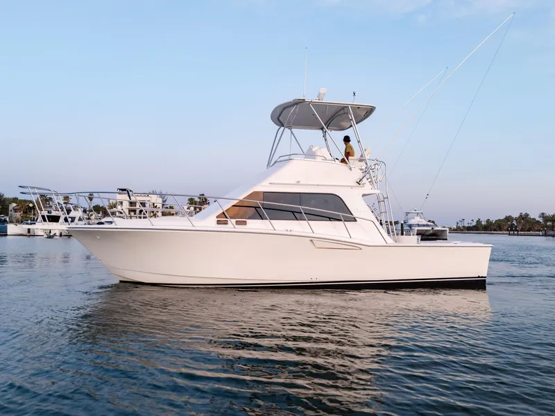 Slide: The Image of 2002 Cabo 35 Flybridge yacht on calm water, side view, clear sky background. - 5