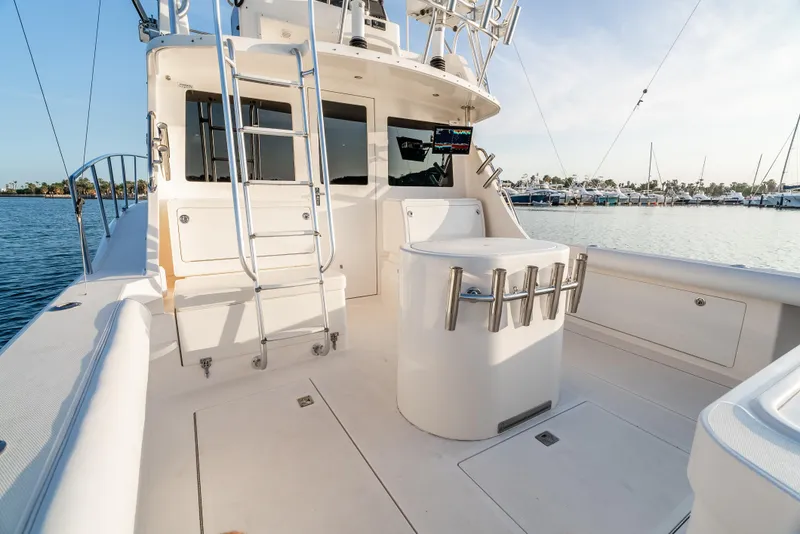 Slide: The Image of 2002 Cabo 35 Flybridge boat deck with ladder and rod holders, docked at marina. - 9