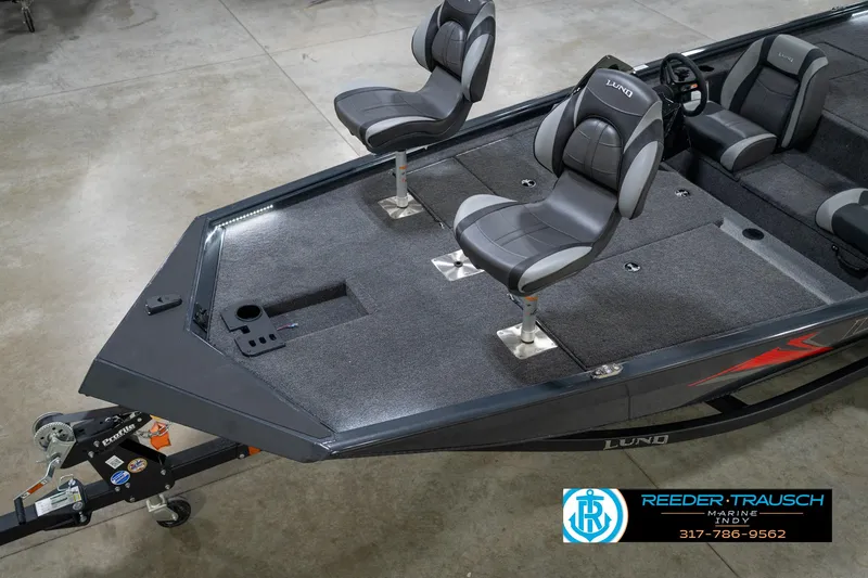 Slide: The Image of 2026 Lund 1775 Renegade fishing boat with gray seating and carpeted deck in showroom. - 10
