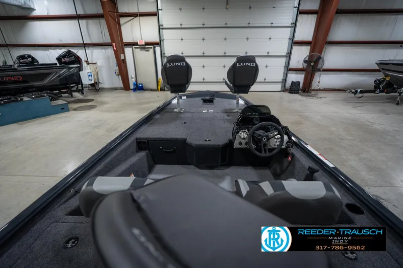 Slide: The Image of 2026 Lund 1775 Renegade boat interior with seating and control panel in a garage setting. - 14