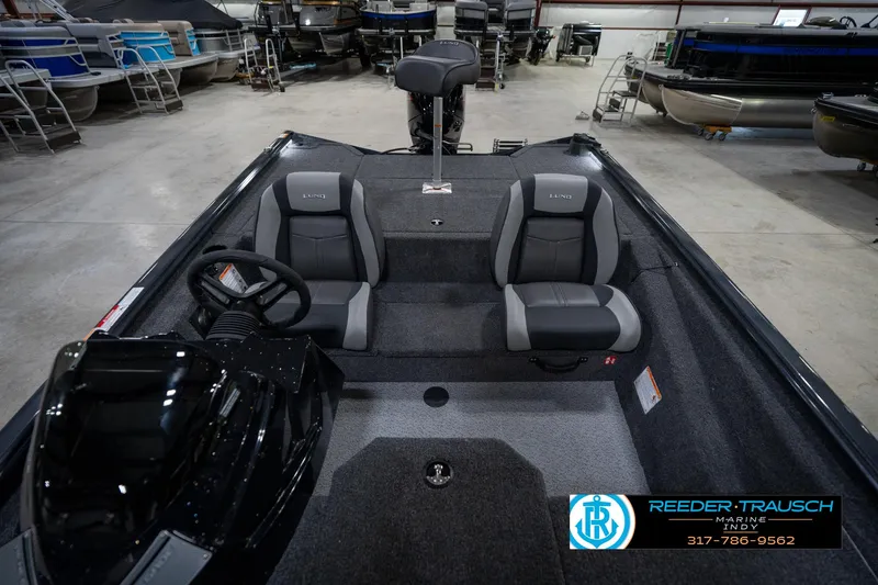 Slide: The Image of 2026 Lund 1775 Renegade boat interior in showroom, featuring seating and storage. - 18