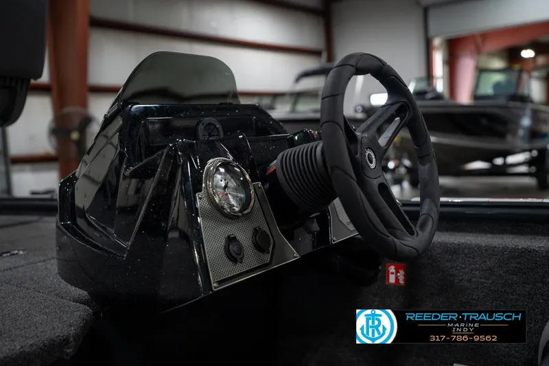 Slide: The Image of 2026 Lund 1775 Renegade boat interior with open storage compartments in a showroom. - 21