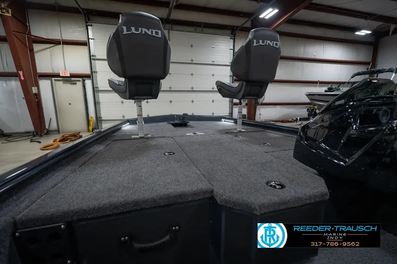 Slide: The Image of 2026 Lund 1775 Renegade boat interior with gray seating and steering wheel in showroom. - 26