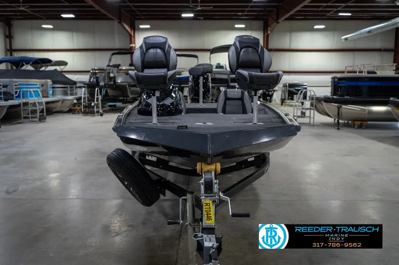 Slide: The Image of 2026 Lund 1775 Renegade boat on trailer in showroom, featuring sleek design and modern seating. - 3