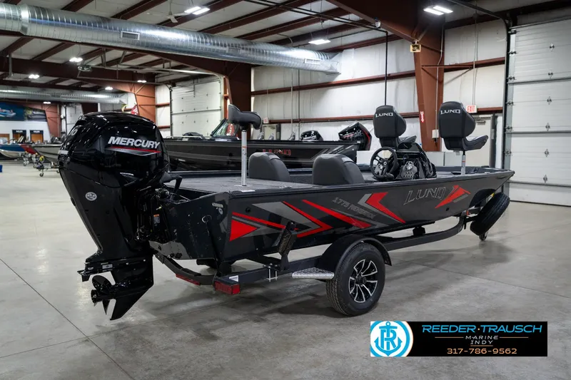 Slide: The Image of 2026 Lund 1775 Renegade boat in warehouse, rear view with motor and ladder. - 6