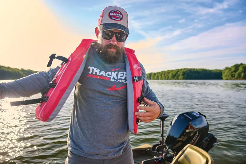 Slide: The Image of Manufacturer Provided Image: Man wearing life jacket on a Tracker Grizzly 14 Jon boat, 2026 model, on a lake. - 49