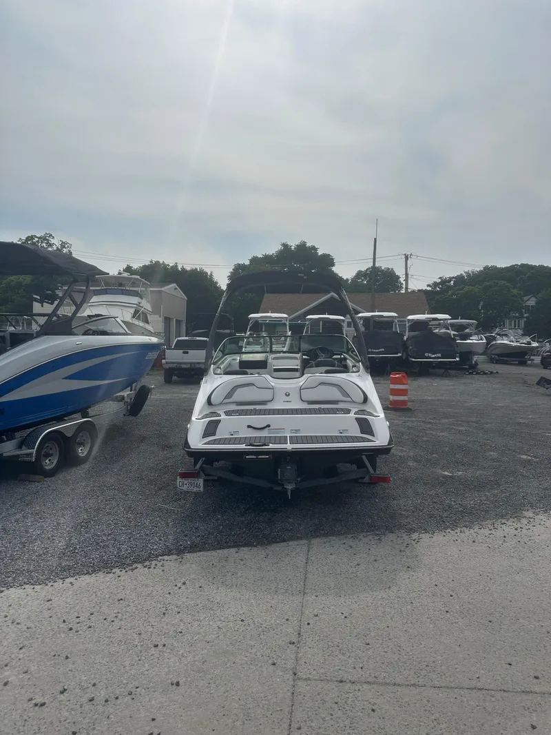 Slide: The Image of 2018 Yamaha Boats AR195 parked in a marina lot under a cloudy sky. - 6