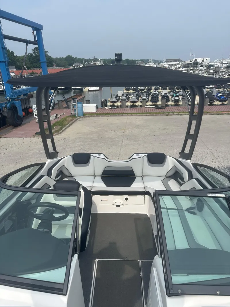 Slide: The Image of 2018 Yamaha Boats AR195 interior with seating and canopy at marina. - 8
