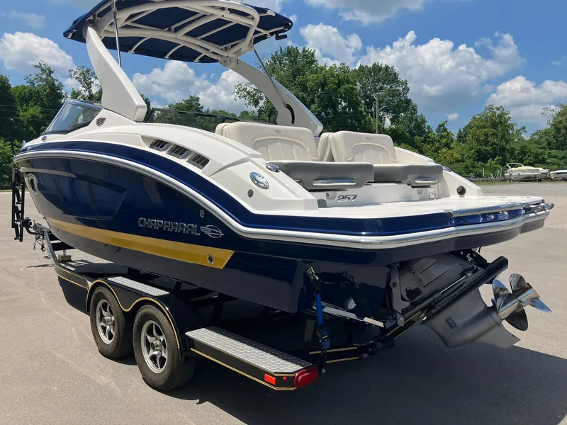 Slide: The Image of 2017 Chaparral 257 SSX boat on trailer, blue and white design, sunny day. - 4