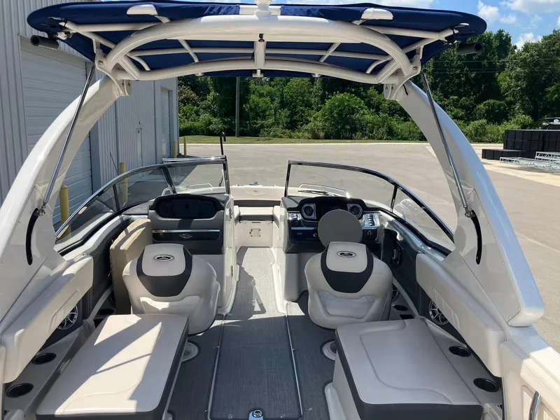 Slide: The Image of 2017 Chaparral 257 SSX boat interior with seating and canopy, parked outdoors. - 7