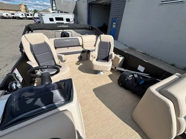 Slide: The Image of 2025 Harris CRUISER 230 SLDH boat interior with beige seating and steering wheel. - 12
