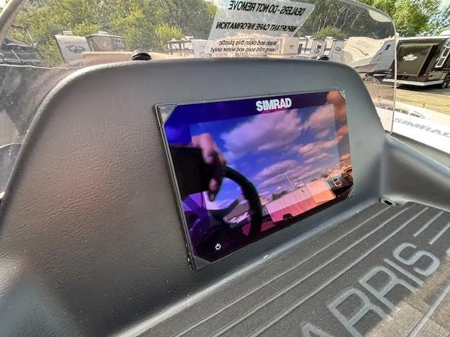 Slide: The Image of 2025 Harris CRUISER 230 SLDH dashboard with Simrad display, outdoor setting. - 24