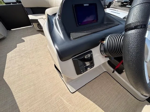 Slide: The Image of 2025 Harris CRUISER 230 SLDH boat dashboard with steering wheel and navigation display. - 25