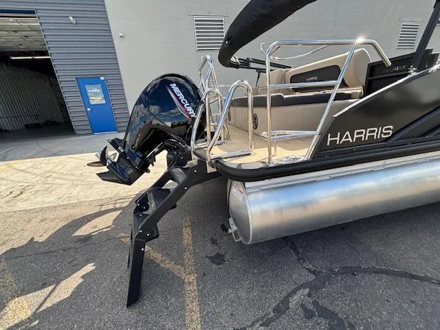 Slide: The Image of 2025 Harris CRUISER 230 SLDH pontoon boat with Mercury outboard motor, docked outdoors. - 6