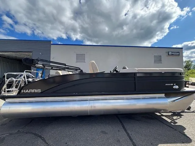Slide: The Image of 2025 Harris CRUISER 230 SLDH pontoon boat parked outdoors under a cloudy sky. - 7
