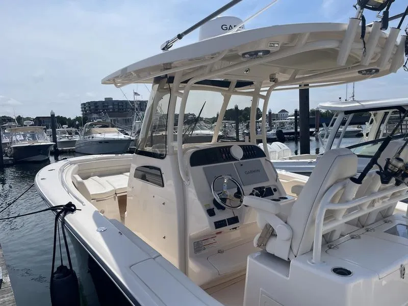 Slide: The Image of 2024 Grady-White 306 CANYON boat docked, featuring a sleek helm and modern design. - 10