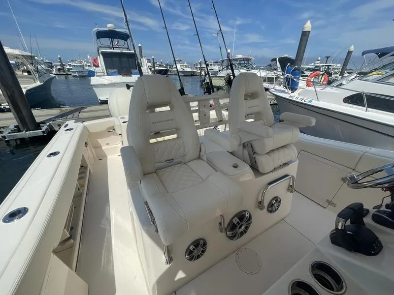 Slide: The Image of 2024 Grady-White 306 CANYON boat interior with plush seating at marina. - 7