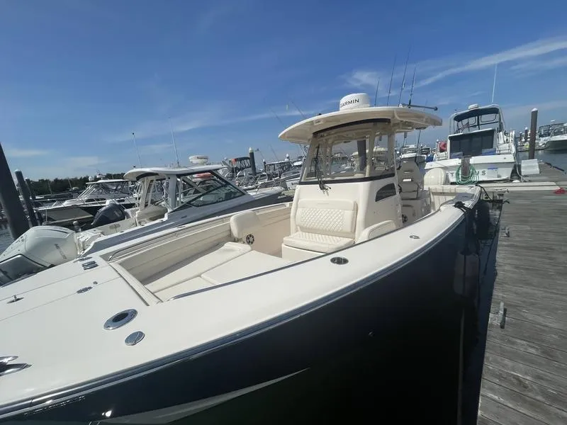 Slide: The Image of 2024 Grady-White 306 CANYON boat docked at marina under clear blue sky. - 9