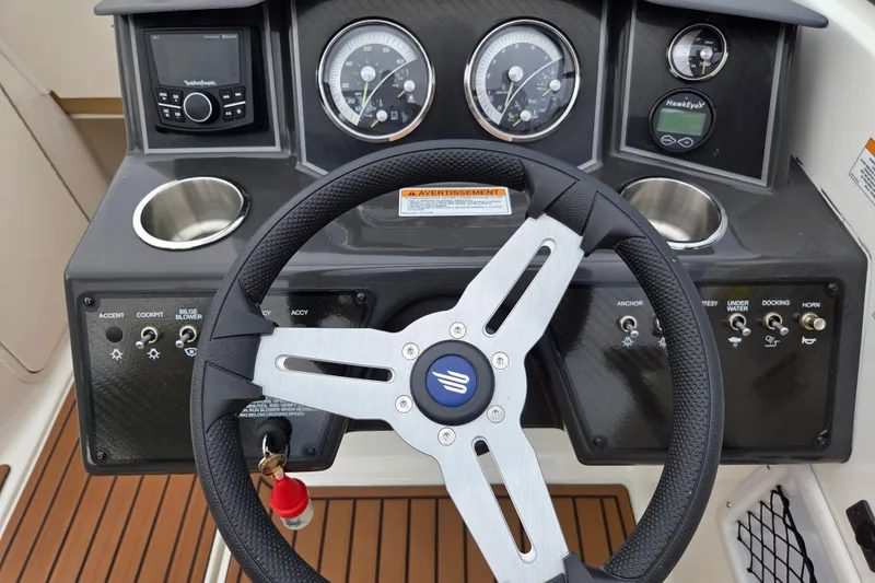 Slide: The Image of 2024 Bayliner VR5 Bowrider I/O dashboard with steering wheel and control panel. - 11