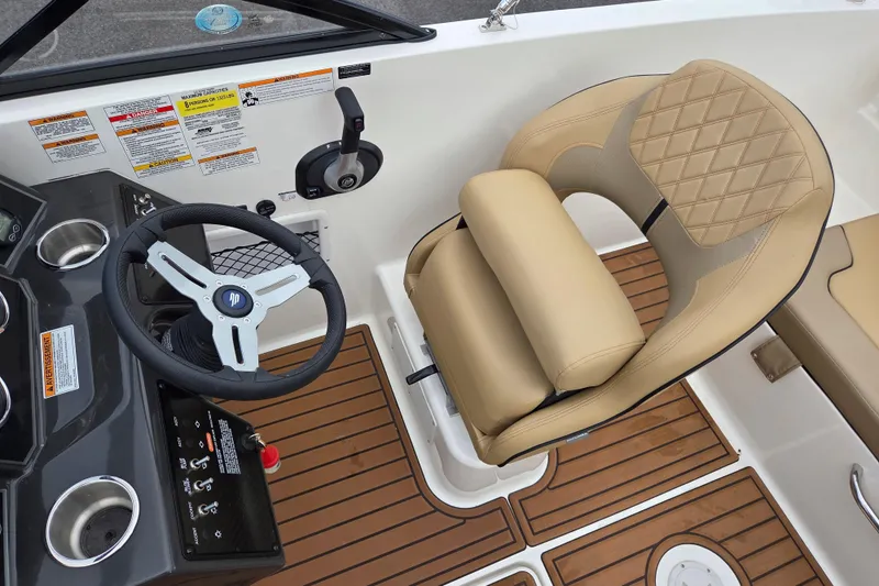 Slide: The Image of 2024 Bayliner VR5 Bowrider I/O helm with tan seat and wood-style flooring. - 13