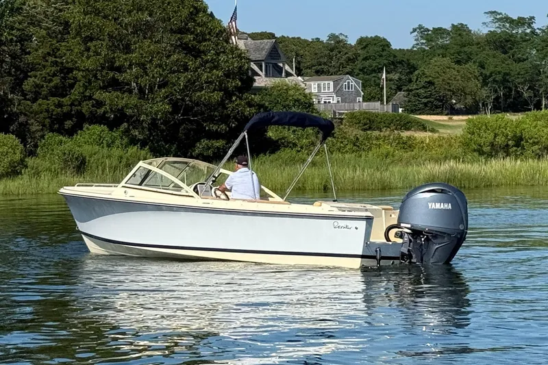 Slide: The Image of 2026 Rossiter R20 Day Boat on calm water, with lush greenery in the background. - 12