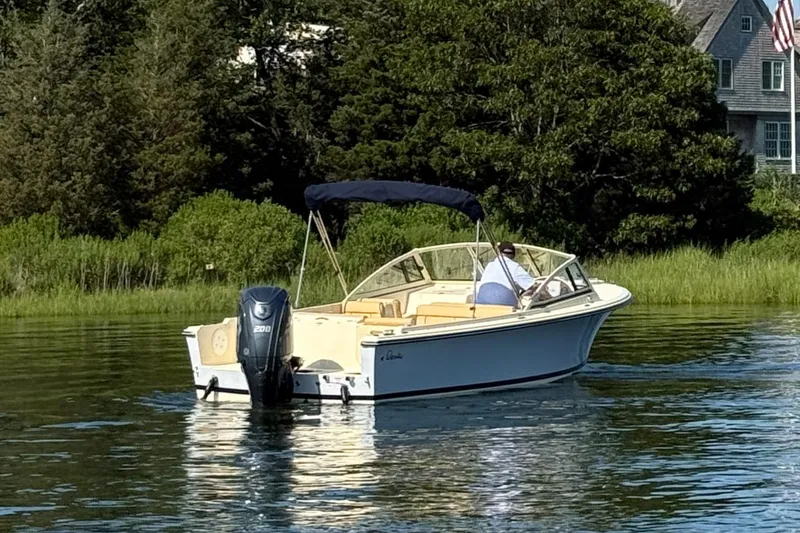 Slide: The Image of 2026 Rossiter R20 Day Boat on calm water near lush greenery and a house. - 8