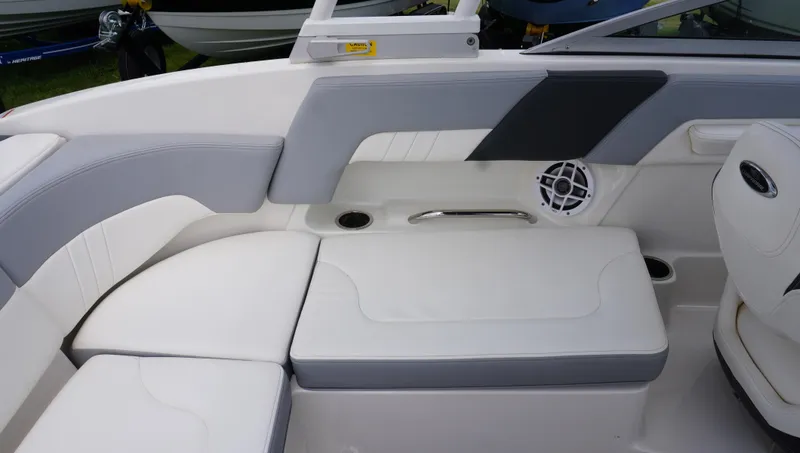 Slide: The Image of 2022 Chaparral 23 SSi boat interior with white and gray seating, speaker, and cup holder. - 12