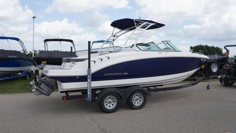 Slide: The Image of 2022 Chaparral 23 SSi boat on trailer, parked outdoors under cloudy sky. - 3