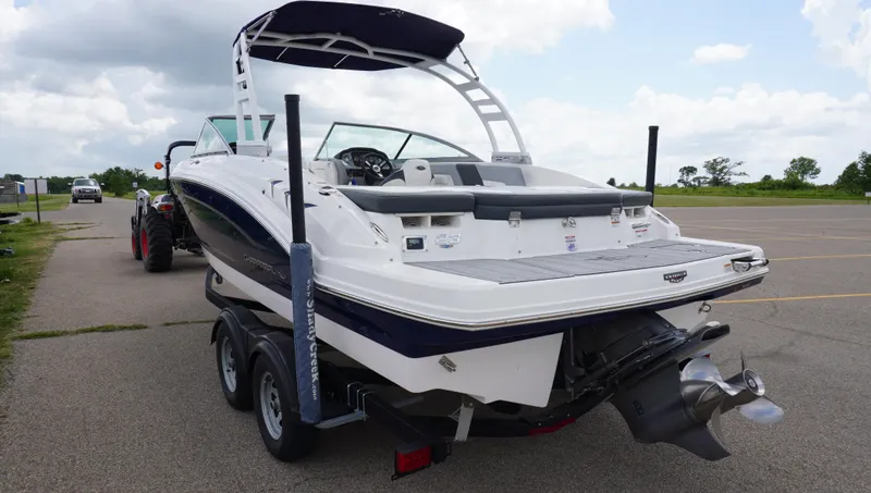 Slide: The Image of 2022 Chaparral 23 SSi boat on trailer, parked on a road under cloudy sky. - 5