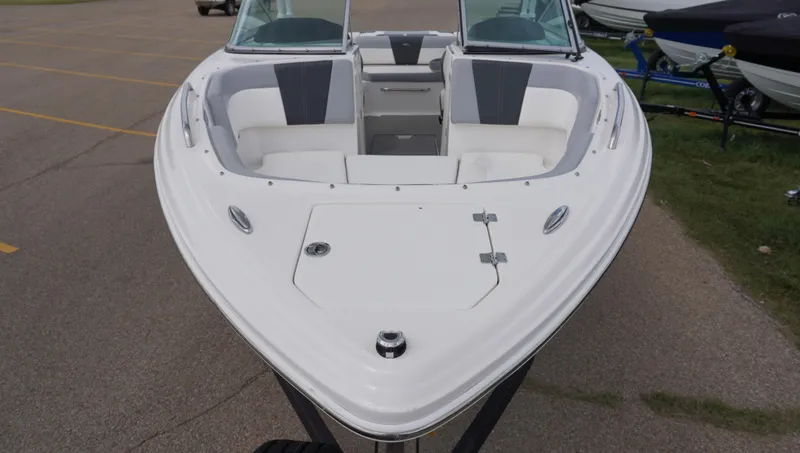 Slide: The Image of 2022 Chaparral 23 SSi boat, white exterior, spacious seating, parked on pavement. - 6