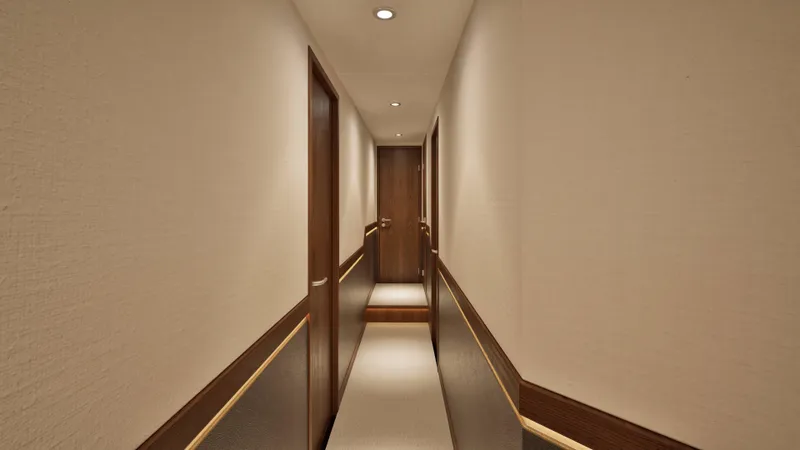 Slide: The Image of Interior hallway of 2026 Hatteras 77 Convertible yacht, featuring elegant wood paneling. - 7