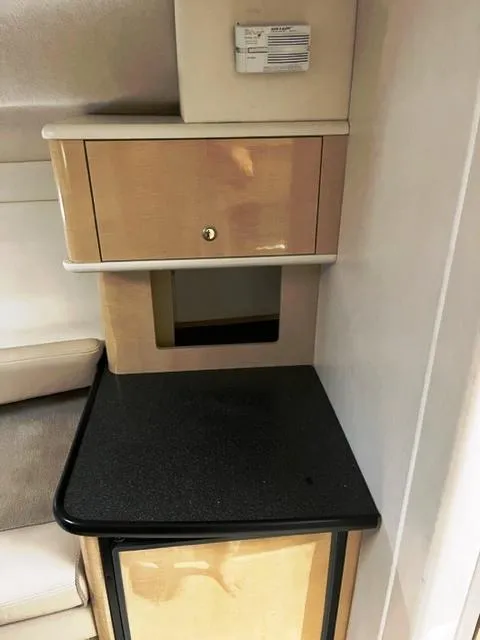 Slide: The Image of 2001 Maxum 2700 SCR interior with wooden cabinetry and black countertop. - 11