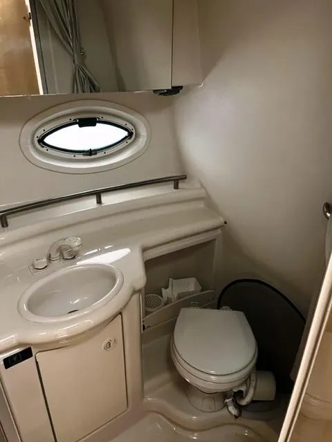 Slide: The Image of 2001 Maxum 2700 SCR boat bathroom with sink, toilet, and porthole window. - 15
