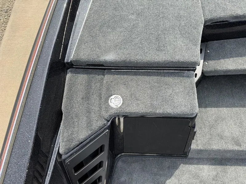 Slide: The Image of 2025 Skeeter ZXR20 boat interior with gray carpeted storage compartments. - 13
