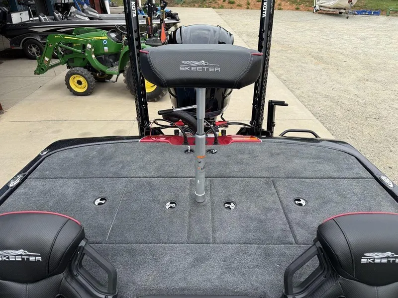 Slide: The Image of 2025 Skeeter ZXR20 boat interior with seating and equipment, parked near a green tractor. - 16