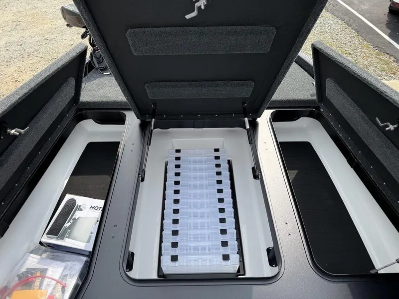 Slide: The Image of 2025 Skeeter ZXR20 boat storage compartment with organized tackle boxes and accessories. - 7