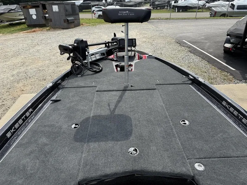Slide: The Image of 2025 Skeeter ZXR20 boat deck with trolling motor and seat, parked outdoors. - 8