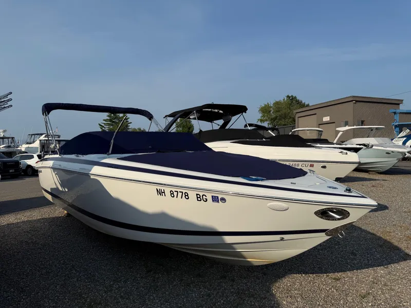 Slide: The Image of 2002 Cobalt 262 boat with cover, parked on gravel lot under clear sky. - 13