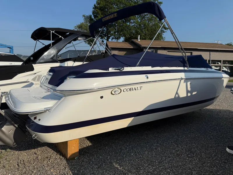 Slide: The Image of 2002 Cobalt 262 boat with blue cover, parked on gravel, sunny day. - 16