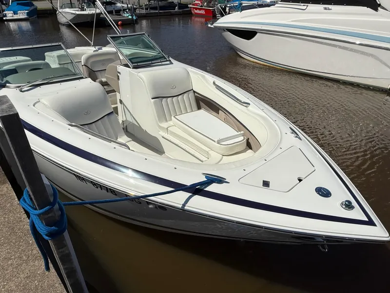 Slide: The Image of 2002 Cobalt 262 boat docked in marina, featuring sleek white design and spacious seating. - 2