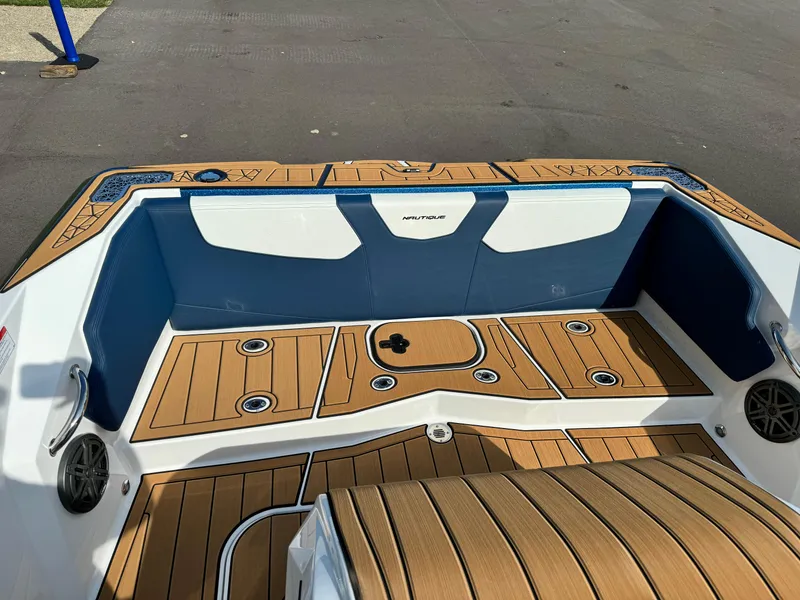 Slide: The Image of 2025 Nautique Ski 200 boat interior with teak flooring and blue-white seating. - 13