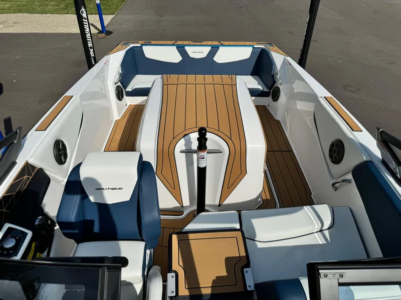 Slide: The Image of 2025 Nautique Ski 200 boat interior with teak flooring and blue-white seating. - 14